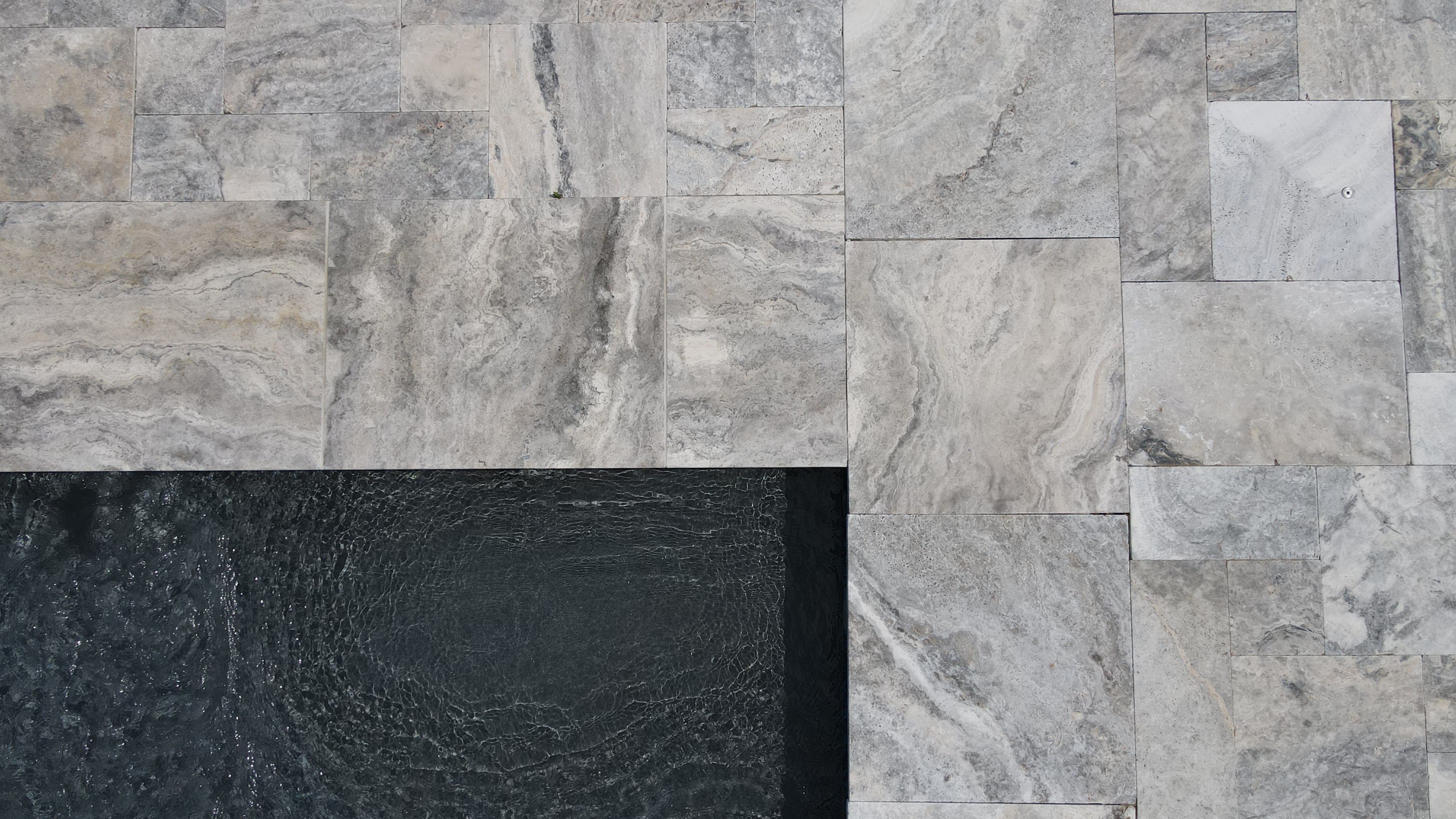 silver tumbled travertine blending light to dark greys with 